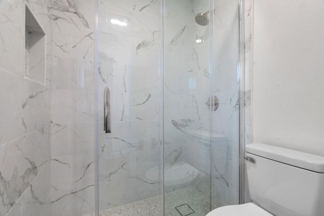 Bathroom with toilet and a marble finish shower | Image 25