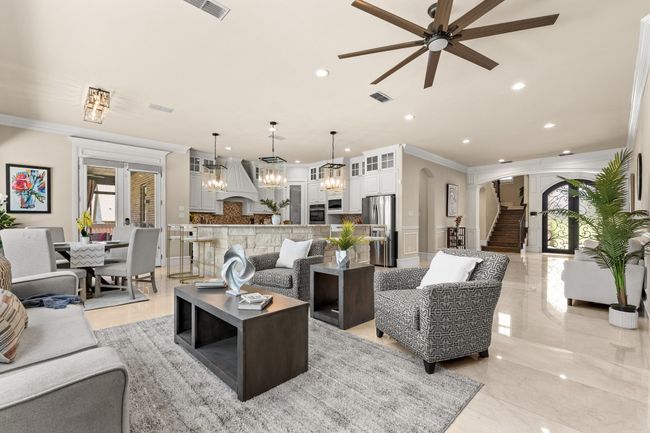 Living area with ornamental molding, ceiling fan, arched walkways, recessed lighting, and stairs | Image 10