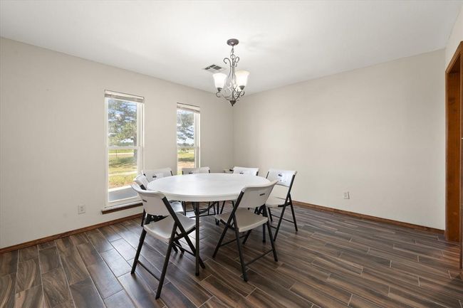 Dining room featuring a chandelier, dark wood-style flooring, and baseboards | Image 9