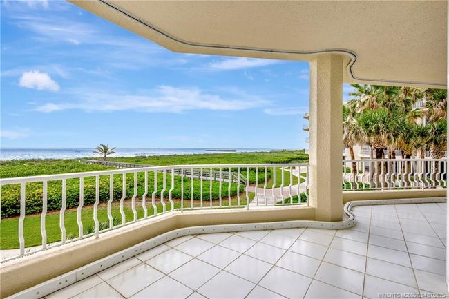 Spacious and winding balcony wraps around the entire east side of the condo. Plenty of room to relax and enjoy the sparkling blue waters of the Atlantic Ocean. | Image 10