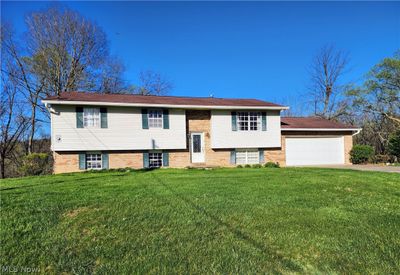 Bi-level home featuring a garage and a front lawn | Image 2