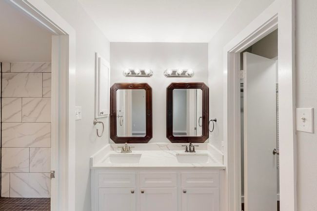 Bathroom with a tile shower, double vanity, and a sink | Image 23