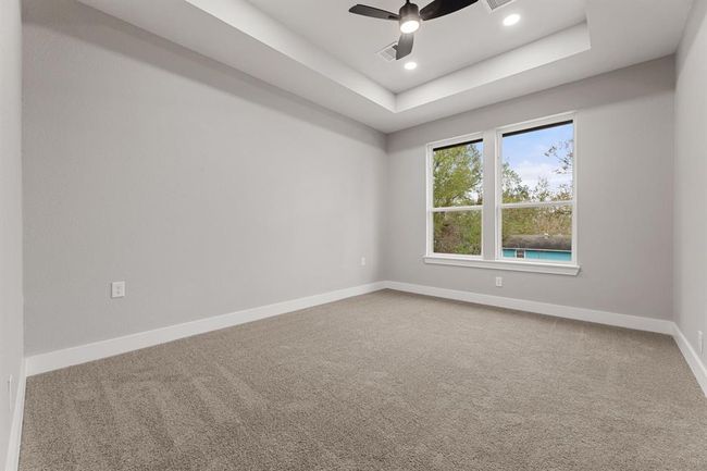 Welcome to your new primary bedroom! This large bedroom offers recessed lighting, a contemporary tray ceiling, and plenty of space to unwind. | Image 19