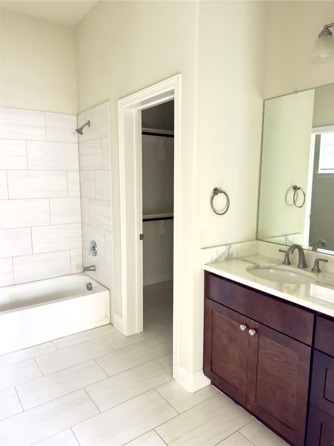 Bathroom with vanity, shower / bathtub combination, and a walk in closet | Image 9