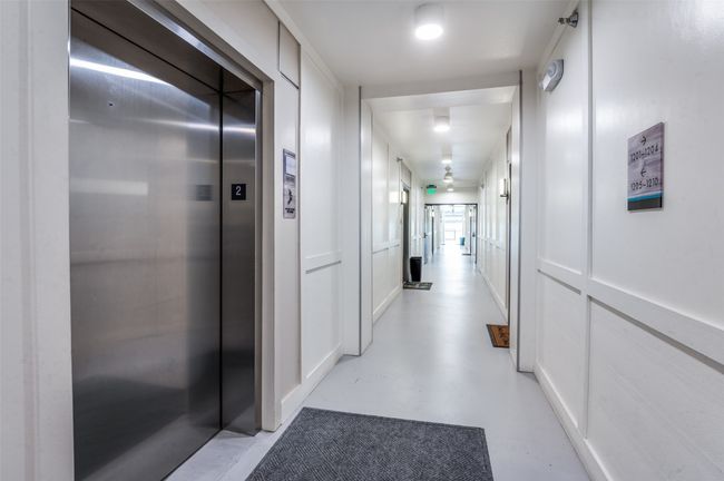 Hall with elevator, finished concrete flooring, and a decorative wall | Image 23