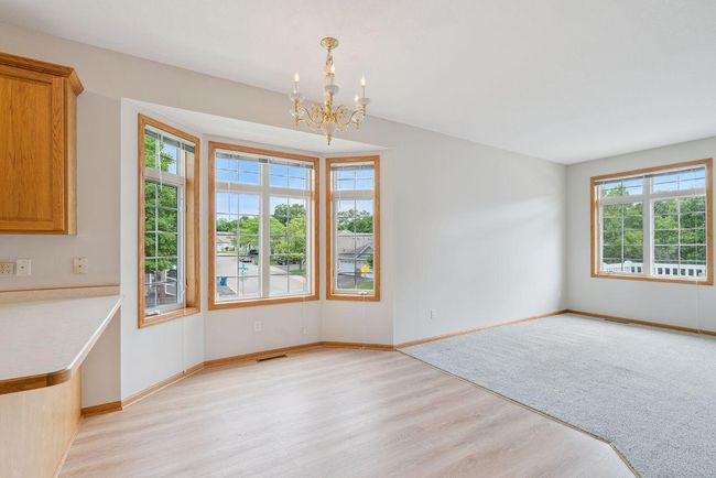 Informal dining area with bay window, neighboring living room with gas fireplace. | Image 9