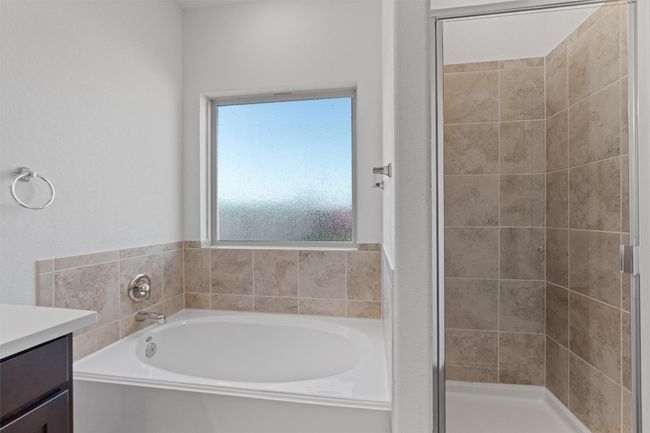 Full bath featuring a stall shower, a garden tub, and vanity | Image 16