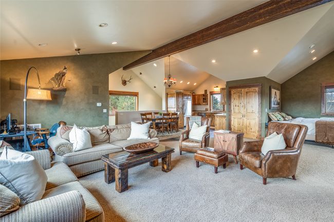 Caretaker Quarters / Guest House. Carpeted living room with lofted ceiling with beams, a chandelier, and recessed lighting | Image 76