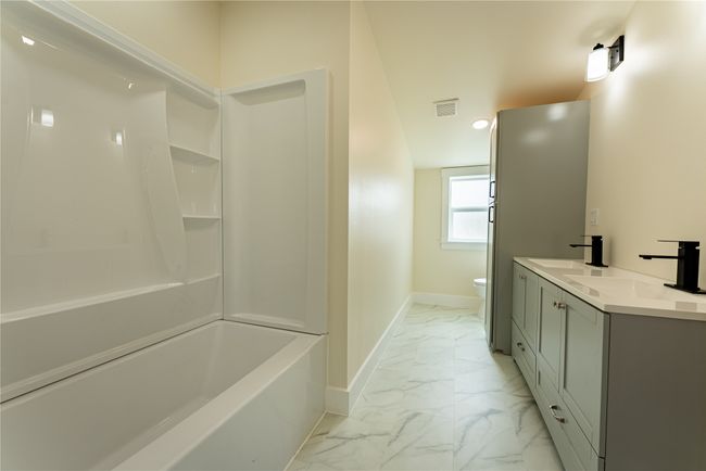 Bathroom with toilet, marble finish floor, baseboards, and a sink | Image 18