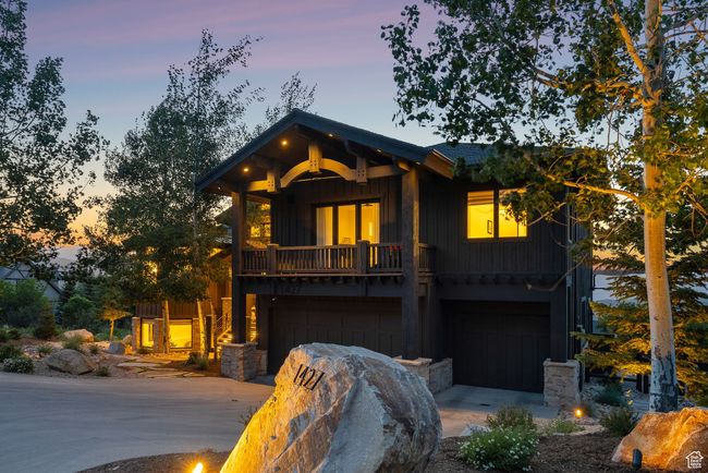 View of front facade with board and batten siding, an attached garage, and driveway | Image 93