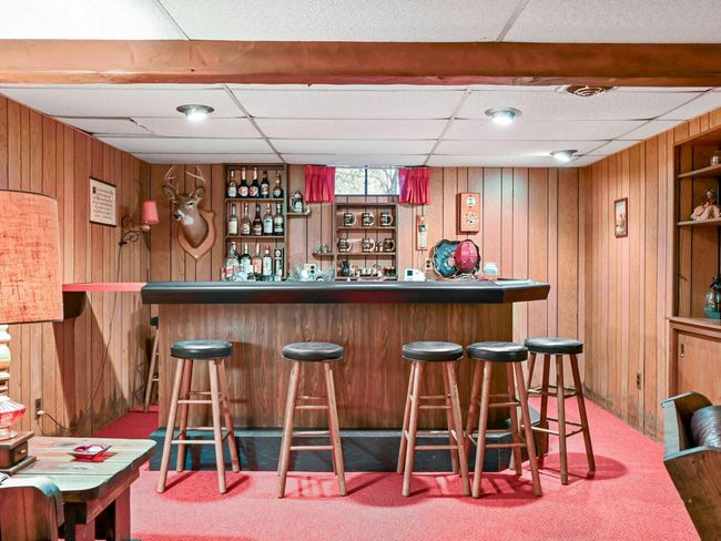 Bar with carpet flooring, wooden walls, and a drop ceiling | Image 29