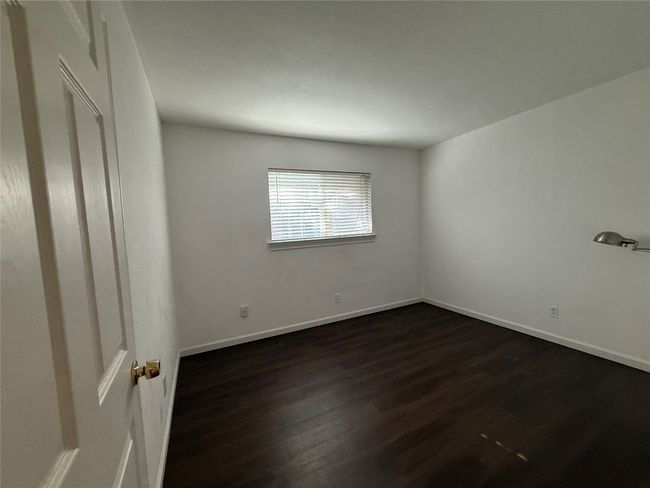 Empty room with dark wood-style floors and baseboards | Image 18