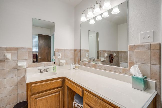 Bathroom with tile walls, vanity, and wainscoting | Image 26