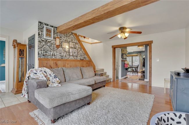Living area featuring light wood-type flooring, a ceiling fan, and beamed ceiling | Image 10