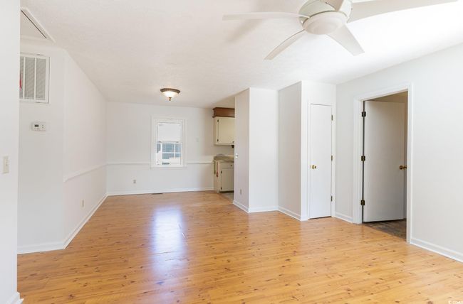 Unfurnished living room with ceiling fan and light hardwood / wood-style floors | Image 4
