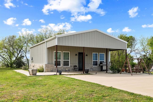 Front of barndo guest house 2/1 featuring stone siding, covered porch, and a front lawn | Image 27