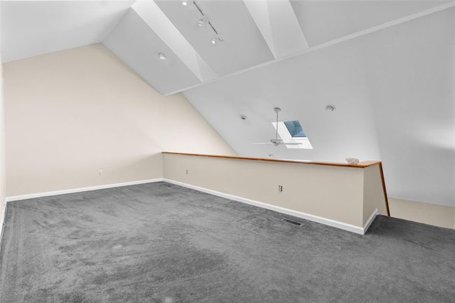 Additional living space featuring vaulted ceiling, a skylight, carpet flooring, baseboards, and ceiling fan | Image 19