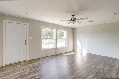 Empty room with ceiling fan, ornamental molding, and hardwood / wood-style floors | Image 2