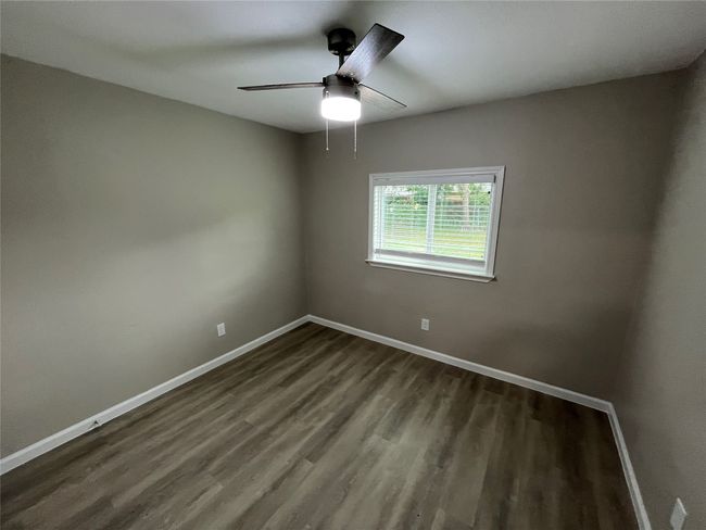 Spare room with dark wood finished floors, baseboards, and ceiling fan | Image 16
