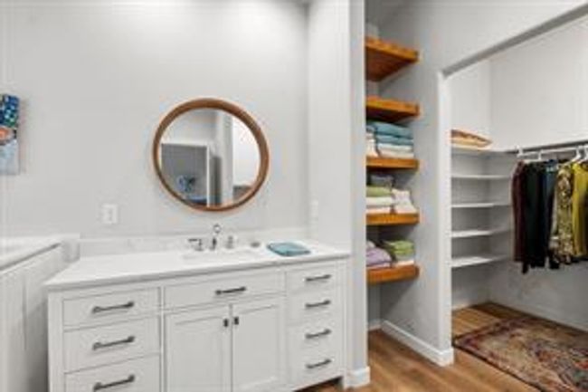 Bathroom with vanity, a walk in closet, and wood finished floors | Image 10
