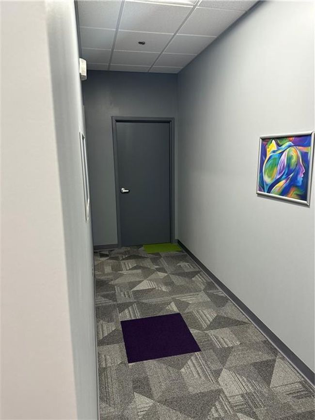 Hall with a drop ceiling and dark carpet | Image 20