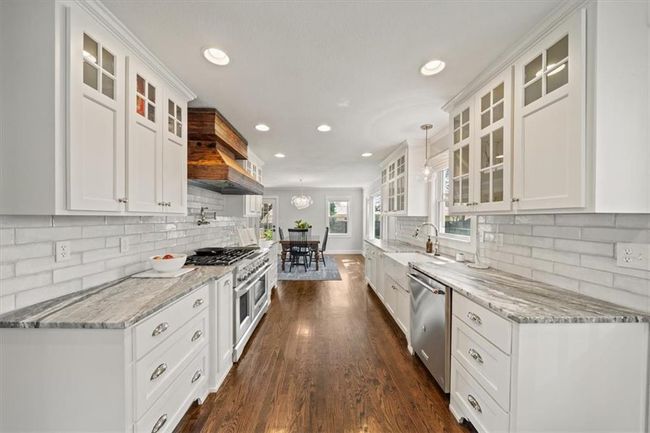 Kitchen featuring recessed lighting, a sink, white cabinets, and appliances with stainless steel finishes | Image 8