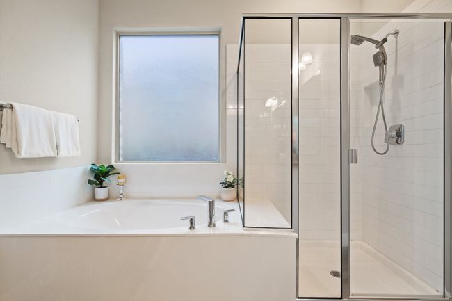 Bathroom with healthy amount of natural light, a bath, and a stall shower | Image 12