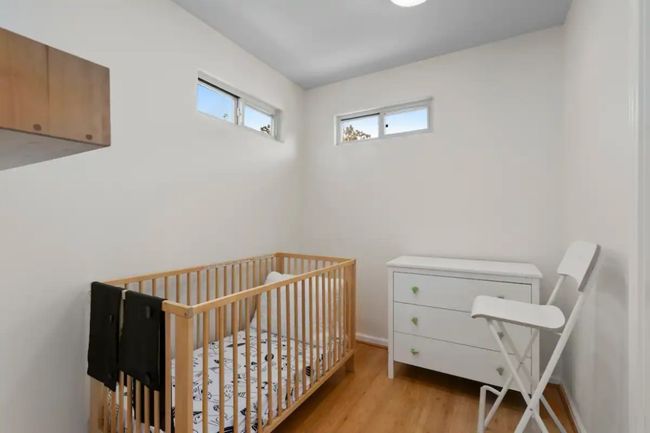 Bedroom with wood finished floors and a nursery area | Image 18