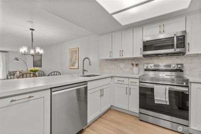 Kitchen renovation includes upgrades appliances including range, dishwasher, and microwave. Updated tile backsplash, quartz counters and more. | Image 3