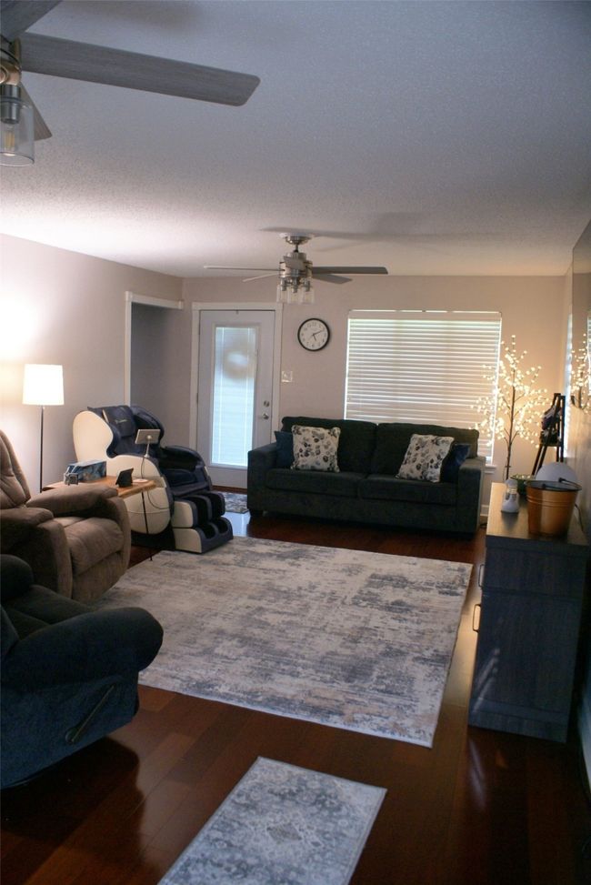 Living area with ceiling fan, wood finished floors, and plenty of natural light | Image 13