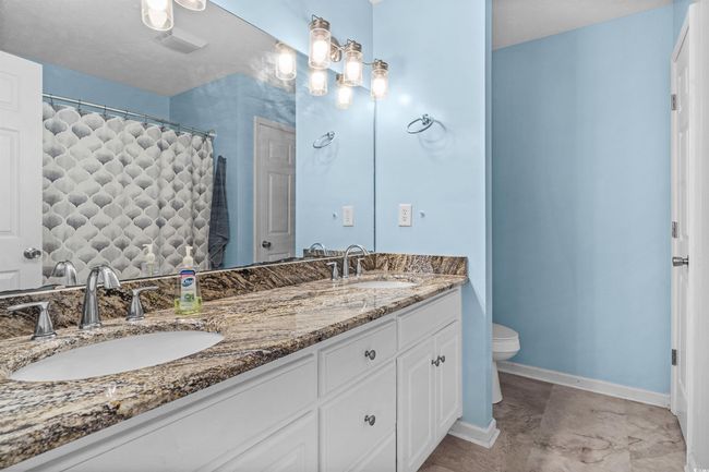 Bathroom featuring double vanity and a shower with shower curtain | Image 12