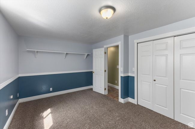 Unfurnished bedroom featuring a closet, baseboards, carpet flooring, and a textured ceiling | Image 24