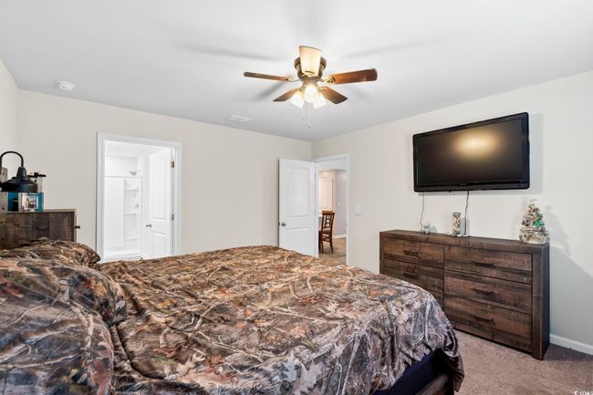 Carpeted bedroom with ceiling fan and ensuite bathroom | Image 17