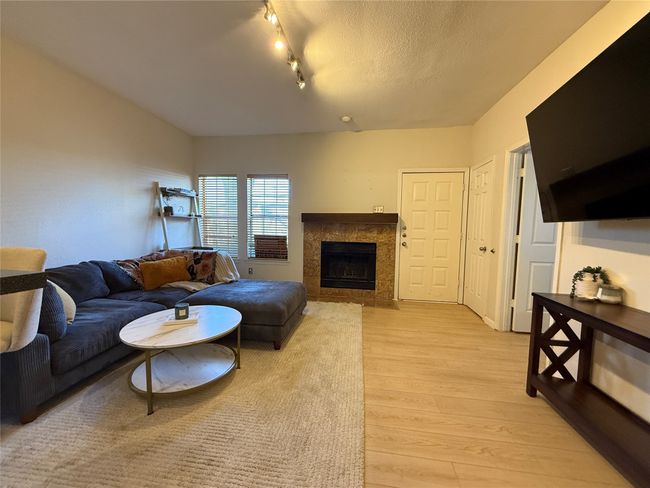 Living area featuring a high end fireplace, light wood-type flooring, and a textured ceiling | Image 22