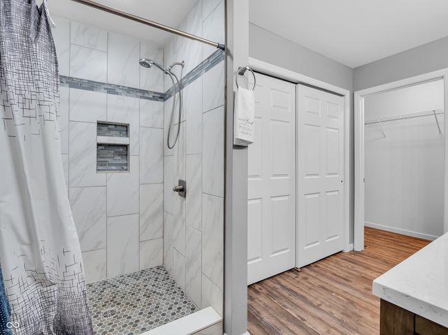 bathroom with custom tiled shower with niche, also a large linen closest | Image 14
