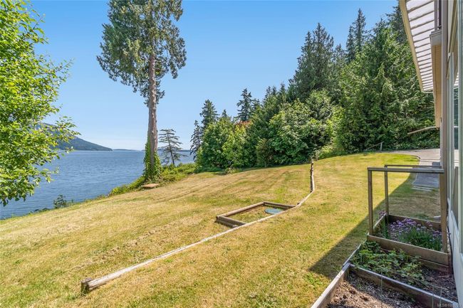 View of grassy yard with a garden and a water view | Image 68