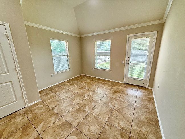 Dining Area with vaulted ceiling, crown molding, and light tile patterned floors | Image 7