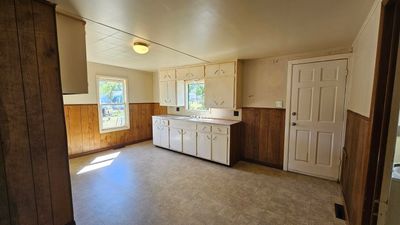 Kitchen featuring wood walls and sink | Image 2