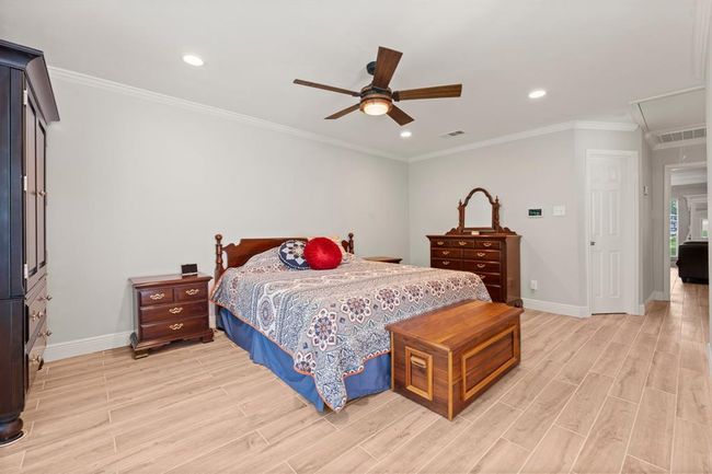 Spacious bedroom with a ceiling fan and ample natural light. | Image 20
