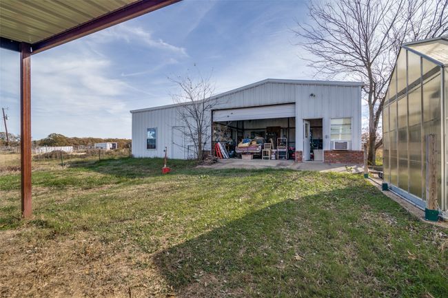 View of yard with an outbuilding, a garage, and a pole building | Image 37