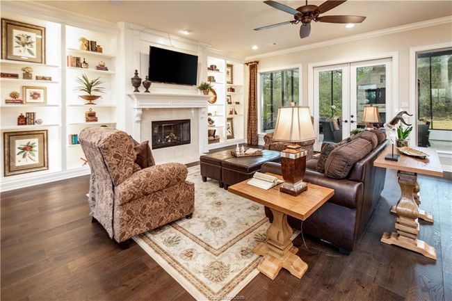 Living room with a ceiling fan, dark wood-style floors, and a wealth of natural light | Image 6