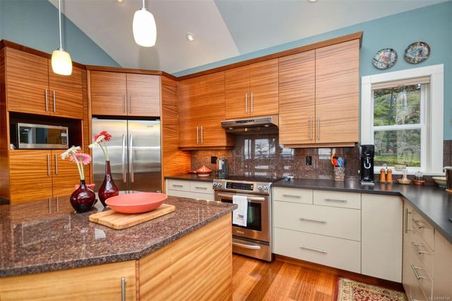 Kitchen with stainless steel appliances, beautiful counters, plenty of storage | Image 7