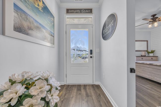 Entryway featuring wood finished floors, crown molding, baseboards, and a ceiling fan | Image 5