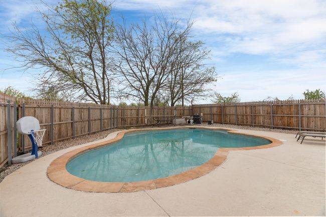 View of swimming pool featuring a fenced in pool, a patio, and a fenced backyard | Image 8