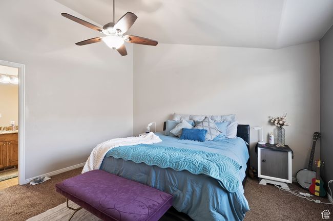 Carpeted bedroom with vaulted ceiling, connected bathroom, and ceiling fan | Image 17