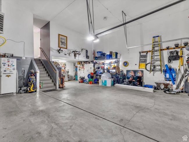 Wow what a garage... that is extra deep and wide, plus it's also heated. Stairway to butler pantry/mudroom off laundry room area | Image 31