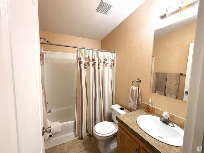 Main bathroom featuring toilet, vanity, and shower / bathtub combination with curtain | Image 32