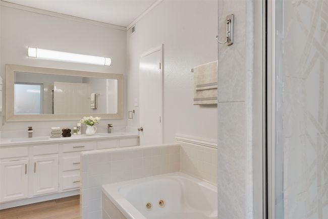 Full bathroom with a jetted tub, double vanity, and ornamental molding | Image 14