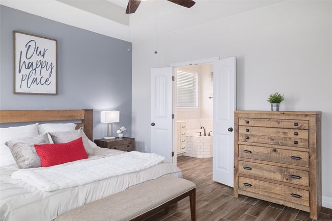 Bedroom with dark wood-type flooring, a ceiling fan, and ensuite bath | Image 19