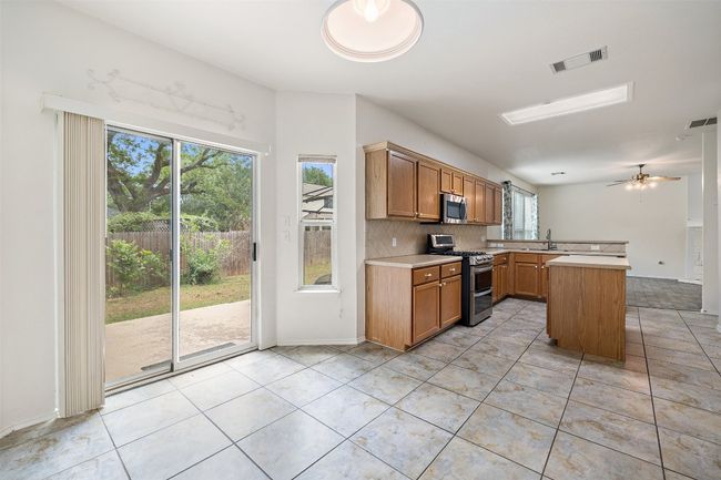 Kitchen featuring stainless steel appliances, visible vents, and a wealth of natural light | Image 17